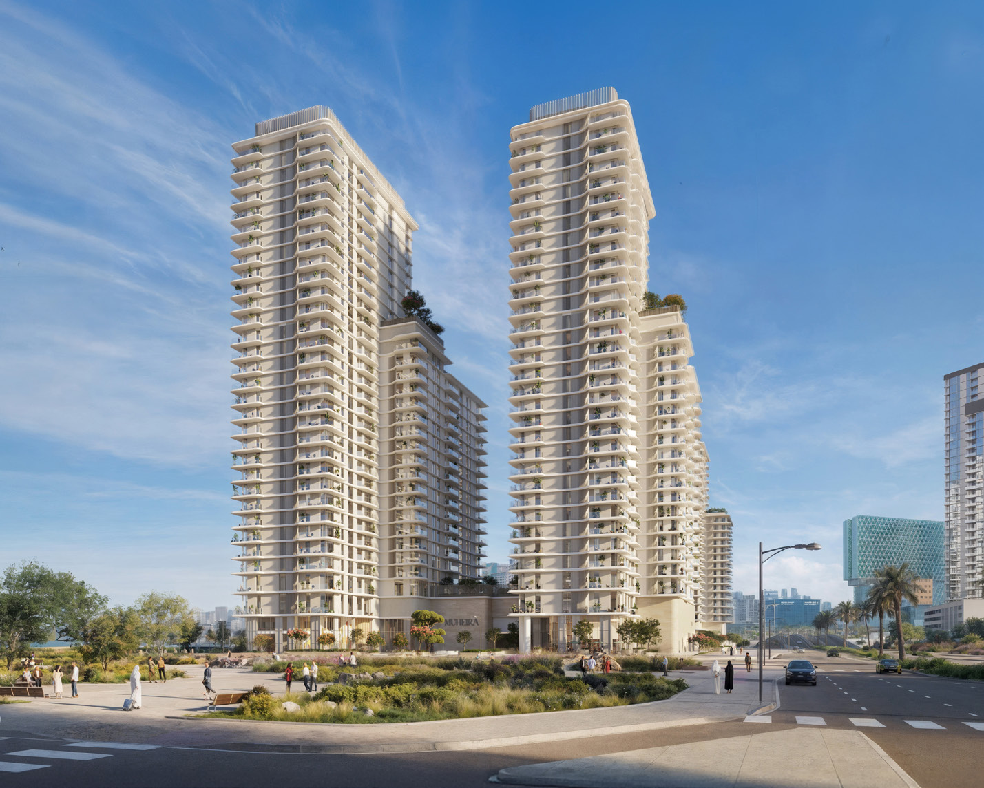 Two tall cream towers with curved balconies above a landscaped street corner