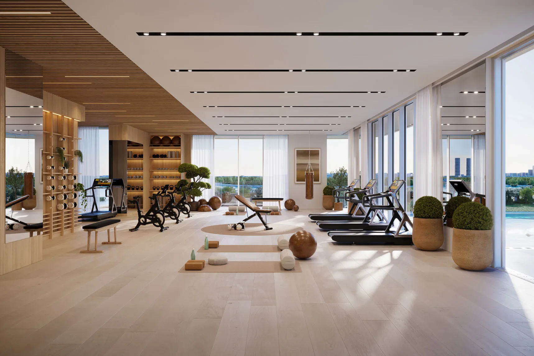 Light-filled gym with treadmills, bikes and yoga mats beside the pool